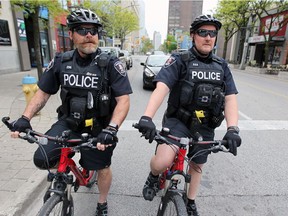 Windsor Police Service City Centre Patrol Constables Angus McKenzie, left, and Gary Boudreau on their bicycles on Ouellette Avenue on May 14.