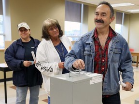 Unifor Local 195 member Milenko Moravac, right, smiles while voting on a new contract with other, unidentified members May, 21, 2017. Striking members voted 75 per cent in favour of a new contract with Flex-N-Gate Lakeshore.