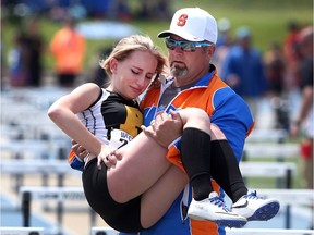 In this 2017 file photo, Sandwich Sabres' head track and field coach Rob Moore helps an injured Alexandra Newhook, from General Amherst, off the track after she was injured while running hurdles at the WECSSAA track and field championships.