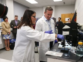 Rosa-Marie Ferraiuolo, a PhD candidate in the Department of Biological Sciences at the University of Windsor, shows Caesars Windsor regional president Kevin Laforet her research on May 23, 2017.