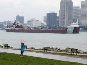 A man out exercising on the Windsor riverfront watches as the lake freighter Philip R. Clarke heads upstream on the Detroit River on May 24, 2017.