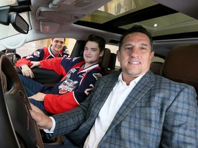 Spitfires team president Bob Boughner, front, is joinged by players Logan Brown, centre, and Mike DiPietro during a news conference on May 5, 2017 to announce FCA Canada's plan to donate the use of 30 new Chrysler Pacificas during the Memorial Cup.