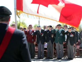 Area veterans,  (R to L) Rev. Ron Matthewman,   Pete Remdenok,  Ron Ewing, Dona Parent,  Joe Klaus, Ralph Mayville along with others salute during the Memorial Cup Garden dedication ceremony at the WFCU Centre in Windsor, Ontario on May 8, 2017.