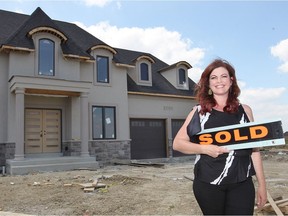 Real estate agent Julie Bondy stands outside a  new, two-storey home on St. Francis Crescent in LaSalle on June 12, 2017.