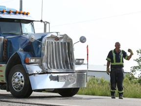 A towing operator prepares to haul away a Peterbilt tractor following a collision involving a school bus on southbound Walker Road June 13, 2017.  Two children were taken to hospital with minor injuries.