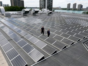 Windsor, Ontario. June 21, 2017.   Karina Richters, front, and Daryl Brisbois with hundreds of solar panels on top of City of Windsor owned Windsor Aquatic and Training Centre and Adventure Bay Family Water Park June 21, 2017.  The panels collect 350 kilowatts.