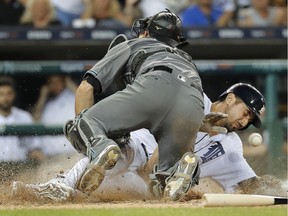 Detroit Tigers' Nicholas Castellanos scores as Arizona Diamondbacks catcher Jeff Mathis can't hold on to the ball in the sixth inning of a baseball game in Detroit on June 13, 2017.