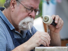 Martin Henly of Henly's Leather Shop works on a piece during Art in the Park at Willistead Park on Saturday, June 3, 2017.