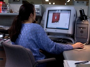 A woman is shown seated at her workplace in Montreal in this 2002 file photo.