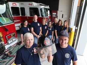Virginia Gherasim and Windsor firefighter Derek Bull hold a recently found firefighter helmet for the late Constantine "Sonny"  Gherasim, Virginia's husband. Looking on are family members, from left to right, Kim Doddridge, Stephen Gherasim,  Kelly Gherasim,  Katie Beausoleil, Joe White, Pam Beausoleil, and Kelsey Beausoleil.  The missing helmet was presented on June 30, 2017, to the family of the late Windsor firefighter.