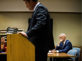 Special Agent Jeff Seipenko, center, listens as Genesee District Judge David Guinn authorizes charges Wednesday, June 14, 2017, in Flint, Mich., for Department of Health and Human Services Director Nick Lyon and Chief Medical Executive Dr. Eden Wells in relation to the Flint water crisis. Lyon is accused of failing to alert the public about an outbreak of Legionnaires' disease in the Flint area, which has been linked by some experts to poor water quality in 2014-15. Wells was charged with obstruction of justice and lying to a police officer.