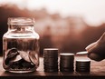 A jar and stacks of coins are shown in this file photo.