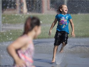 Arial-Jade Pare-Gervais, 7, and her half sister, Stormy Pare-Teskey, 9, left, try to beat the heat at the spray pad at Fred Thomas Park in downtown Windsor, Monday, June 12, 2017.