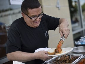 Charles Liston serves up some Italian sausages on June 23, 2017, outside Mezzo at the Italian Village as part of the annual Carrousel of the Nations.