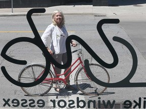 Lori Newton, executive director of Bike Windsor Essex, is pictured through the windows of the grassroots cycling advocacy organization's downtown hub on June 20, 2017.