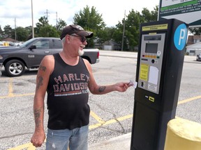 Doug Jones holds a parking lot receipt at the Windsor Health Care Centre on June 19, 2017. Owners of the Windsor Health Centre are changing their parking meters due to public outcry.