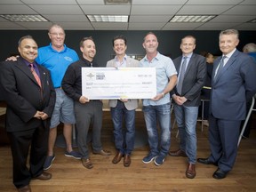 From left, Siyaram Pandey, Preston Harris, Shane Miles, Aldo DiCarlo, Ian France, Chris Houser, and Douglas Kneale hold a cheque as Pandey and his research lab receive funds from the Prostate Cancer Fight Foundation and TELUS Ride for Dad, at the University of Windsor on Tuesday, June 13, 2017.