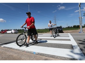 The County of Essex held a press conference on Tuesday, June 27, 2017 to display a newly designed pedestrian crossover. Kirk and Charmaine Godard, visitors to Windsor from British Columbia, use the crossover during a cycling outing.