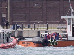 Members of the U.S. Coast Guard give CPR to a male pulled from the Detroit River west of the Ambassador Bridge, June 18, 2017.