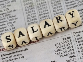 Salary word built with letter cubes on newspaper background. Minimum wage. Image by Getty Images.