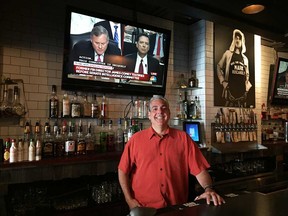 Mark Boscariol, owner of downtown Windsor's Snackbar-B-Q, stands in front of a screen showing CNN's live coverage of James Comey's hearing on June 8, 2017.
