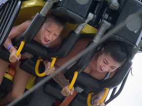 Jamie Sapusak (left) and Sarah Gagnon (right) scream with delight aboard the Fire Ball during Windsor Summer Fest 2016.