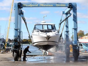(file) An employees with Westport Marina in LaSalle, Ontario sprays off a cabin cruiser as the boating season comes to an end for 2016.