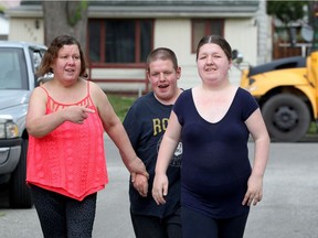Heather Michaluck, right, walks with her mother Penny Michaluck, left, and younger brother Adam outside their home on Partington Avenue.  Heather is a recent graduate of Work Matters.