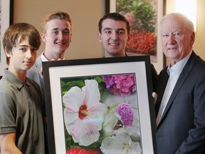 Karl Straky Sr., right, and grandsons, Kurtis Straky, left, Karl Straky IV and Andrew Straky hold a print of a photo taken of Kathleen's garden. The Straky family attended a ceremony for the Kathleen Straky waiting lounge at Windsor Regional Hospital's Met Campus on June 9, 2017.