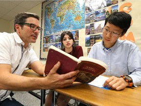 Teacher Roger Fogal helps students Mina Polus and Runze Meng at Catholic Central high school on June 6, 2017.