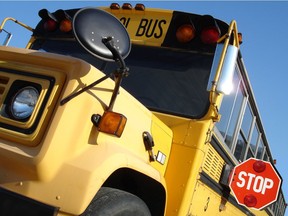 A forward view of an old school bus with stop sign out. Photo by Getty Images.