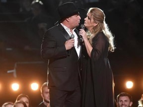 FILE - In this Nov. 2, 2016, file photo, Garth Brooks, left, and Trisha Yearwood perform at the 50th annual CMA Awards at the Bridgestone Arena in Nashville, Tenn. The Lafayette Daily Advertiser reported July 27, 2017, that Brooks and Yearwood bought wedding gifts for a couple who came to a concert in Louisiana last month ahead of their wedding last month. (Photo by Charles Sykes/Invision/AP, File)