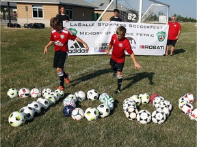 LaSalle Stompers Matthew Hummell, left, and Sebastian Piatkiewicz get ready to disperse soccer balls during a $7000 cheque presentation at Vollmer Complex Monday July 17, 2017.