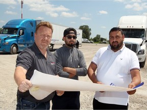 BSD Linehaul operations manager Carl Gatt, left, dispatcher Sima Chandi and co-owner Sam Chandi, right, go over plans for a huge 150,000 square foot warehouse scheduled to start construction in September of this year.  The group were at their Division Road trucking facility Tuesday July 18, 2017.
