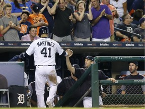 Detroit's Victor Martinez receives a high-five from manager Brad Ausmus after scoring against the San Francisco Giants on a single by Ian Kinsler during the seventh inning at Comerica Park on July 5, 2017 in Detroit.