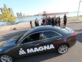 Magna International's Level 3 autonomous vehicle - a modified Cadillac ATS - sits in the foreground as Navdeep Bains, federal minister of innovation, science, and economic development, speaks to media in Windsor on July 31, 2017.