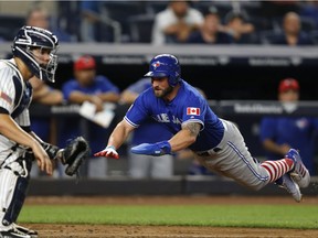 New York Yankees catcher Gary Sanchez, left, waits for the throw as Toronto Blue Jays Kevin Pillar dives home trying to score on Darwin Barney's ninth inning RBI single in a baseball game in New York, July 3, 2017. Pillar scored on the play but the Yankees defeated the Blue Jays 6-3.