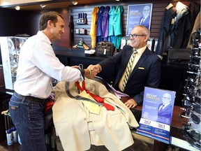 Toronto Blue Jays  broadcaster Joe Siddall, left, donates suits to Marc Dufour, manager at Moore's Clothing for Men in Windsor, on July 14, 2017, during the company's 8th annual Canadian Suit Drive.