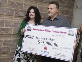 Patti France, president of St. Clair College, left, and Dino Chiodo, president of Unifor Local 444, pose for a cheque presentation at the St. Clair College SportsPlex on July 4, 2017.