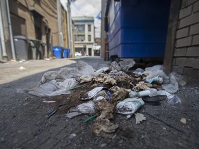 A heap of garbage full of Starbucks containers lies in the alley between Ouellette Avenue and Pelissier Street off University Avenue in downtown Windsor on July 27, 2017.