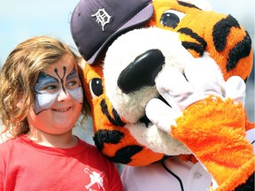 Morgan Gibson shares a moment with Detroit Tigers mascot Paws during the Essex Minor Baseball 60th anniversary celebration on July 15, 2017.