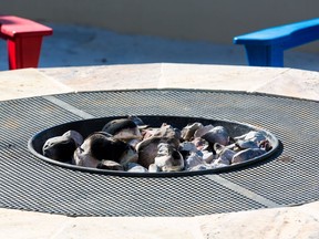 A gas or propane-powered firepit with hot coals and rocks is show in this file photo.