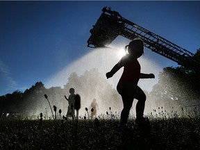 A Windsor Fire Service aerial truck sprays water on area residents at Garry Dugal Park in Windsor on July 6, 2017, during one of this year's Hot Summer Nights stops.