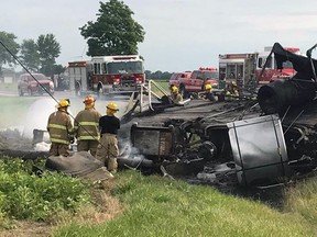 Firefighters look over the aftermath of a fatal crash scene at Highway 77 and Lakeshore Road 310 near Comber on July 26, 2017.