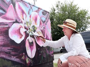Artist Judy Chappus paints a Bell Canada outdoor utility box Tuesday on Malden Road in LaSalle as part of the bell the Bell Boxes Mural Project. Eight artists are painting murals to reflect the history of LaSalle.