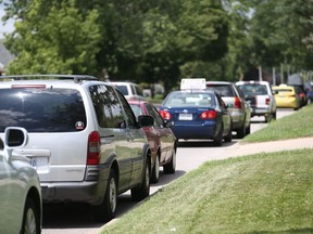 A long line of cars are parked on Dominion Boulevard near Northwood Street in Windsor, Ontario on July  14, 2017.