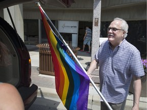 Windsor Pride executive director Bob Williams carries the Pride flag out of the organization's Pelissier Street garage location on July 3, 2017, as volunteers helped him move to a new location downtown.