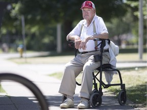 Patrick Dunn, 87, sits at a bus stop where he was recently robbed, located outside his Rivard Avenue apartment in East Windsor, July 5, 2017.