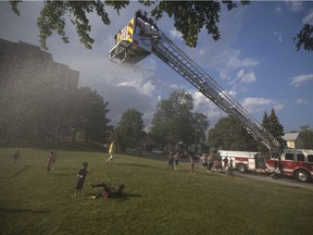 David Kehoe, 5, left, is chased by James Walsh, 5 as they play in the water from the aerial ladder during Hot Summer Nights hosted by Windsor Fire and Rescue at Fred Thomas Park, Thursday, July 27, 2017.