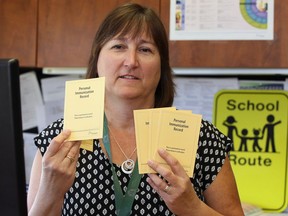 Judy Allen, manager of the  Healthy Schools program of the Windsor-Essex County Health Unit, holds personal immunization booklets in this September 2016 photo.